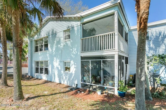 3434 Blanding Blvd Unit 201, Jacksonville, FL 32210 - rear view of house with a balcony, stucco siding, and a sunroom