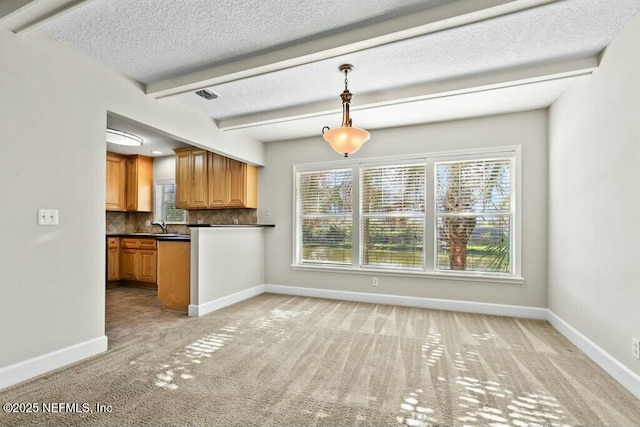 3434 Blanding Blvd Unit 201, Jacksonville, FL 32210 - kitchen with baseboards, dark countertops, light carpet, beam ceiling, and backsplash