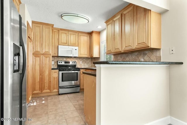 3434 Blanding Blvd Unit 201, Jacksonville, FL 32210 - kitchen with light tile patterned flooring, a peninsula, stainless steel appliances, dark countertops, and decorative backsplash