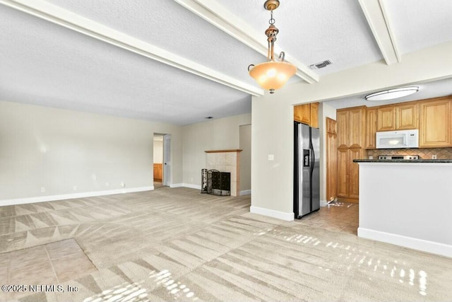 3434 Blanding Blvd Unit 201, Jacksonville, FL 32210 - unfurnished living room with a textured ceiling, a tile fireplace, baseboards, beam ceiling, and light colored carpet
