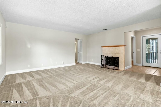 3434 Blanding Blvd Unit 201, Jacksonville, FL 32210 - unfurnished living room with carpet flooring, baseboards, a textured ceiling, visible vents, and a tiled fireplace
