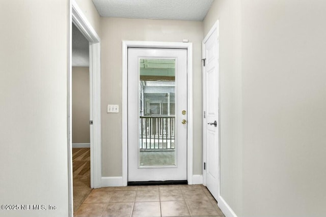 3434 Blanding Blvd Unit 201, Jacksonville, FL 32210 - entryway featuring light tile patterned flooring, a textured ceiling, baseboards, and a wealth of natural light