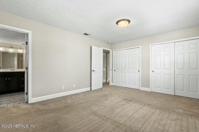 3434 Blanding Blvd Unit 201, Jacksonville, FL 32210 - unfurnished bedroom featuring carpet flooring, ensuite bathroom, baseboards, visible vents, and two closets