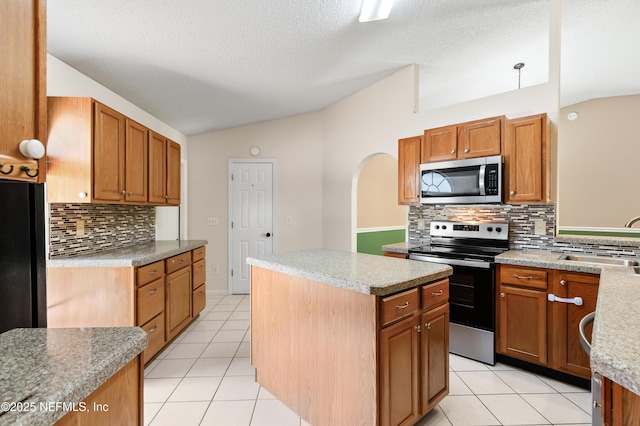 3387 Guernsey Ct, Jacksonville, FL 32226 - kitchen with lofted ceiling, a kitchen island, stainless steel appliances, and a sink