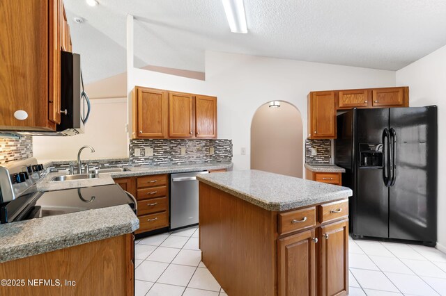 3387 Guernsey Ct, Jacksonville, FL 32226 - kitchen with lofted ceiling, light tile patterned flooring, a kitchen island, decorative backsplash, and appliances with stainless steel finishes