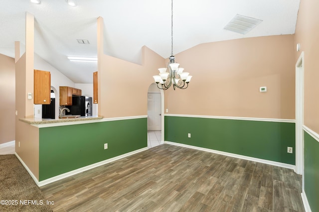 3387 Guernsey Ct, Jacksonville, FL 32226 - unfurnished dining area featuring lofted ceiling, an inviting chandelier, wood finished floors, visible vents, and baseboards