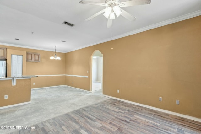 spare room with arched walkways, visible vents, crown molding, and ceiling fan with notable chandelier