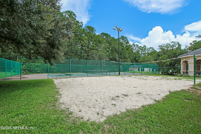 view of home's community with a yard, fence, a tennis court, and volleyball court