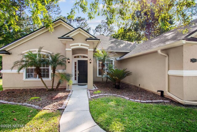 745 Austin Pl, Saint Johns, FL 32259 - view of front of home featuring stucco siding, roof with shingles, and a front lawn
