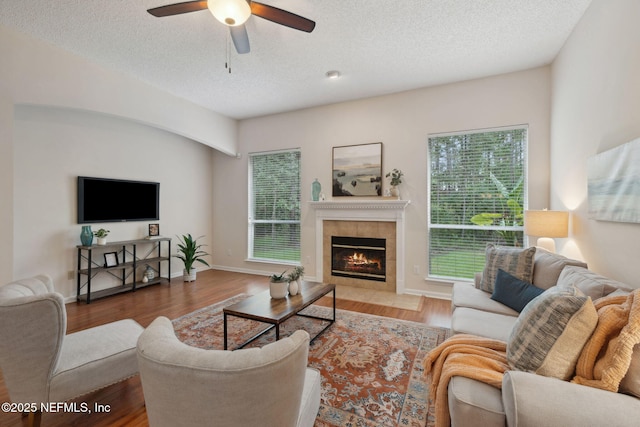 745 Austin Pl, Saint Johns, FL 32259 - living area with ceiling fan, a tile fireplace, a textured ceiling, wood finished floors, and baseboards