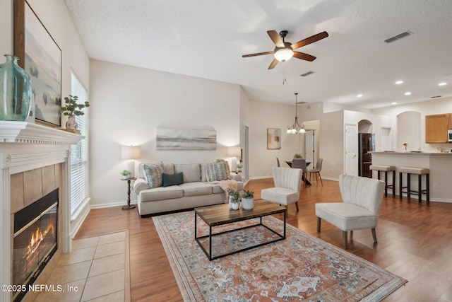 745 Austin Pl, Saint Johns, FL 32259 - living area featuring arched walkways, a ceiling fan, light wood finished floors, a tile fireplace, and baseboards