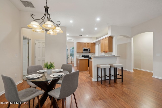 745 Austin Pl, Saint Johns, FL 32259 - dining area with arched walkways, light wood finished floors, a chandelier, baseboards, and recessed lighting