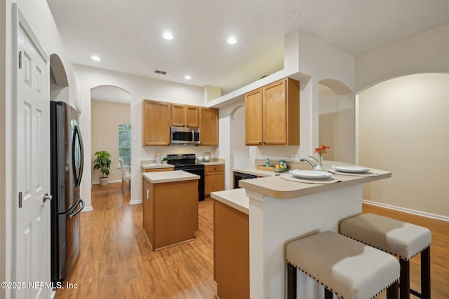 745 Austin Pl, Saint Johns, FL 32259 - kitchen with stainless steel microwave, electric range, freestanding refrigerator, arched walkways, and a peninsula