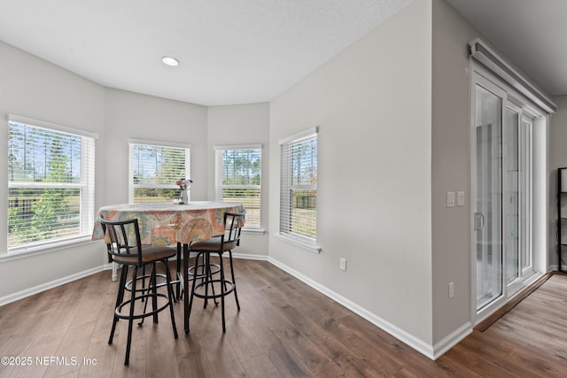 dining room featuring dark wood-style flooring, baseboards, and recessed lighting