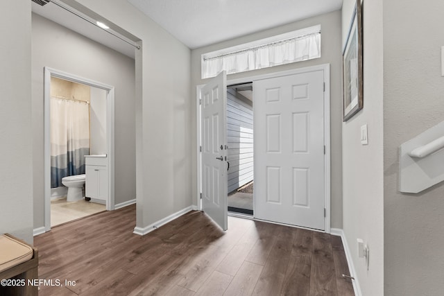 entrance foyer featuring dark wood-style flooring, baseboards, and visible vents