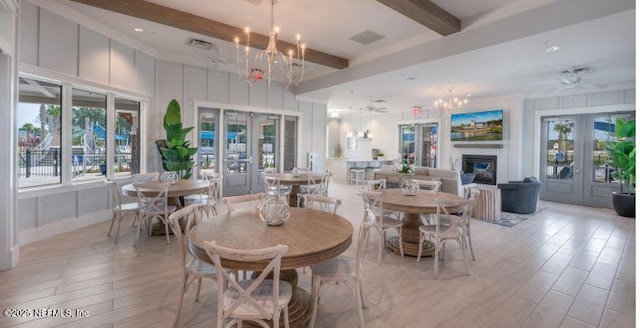 436 Watervale Dr, Saint Augustine, FL 32092 - dining space featuring french doors, beam ceiling, a glass covered fireplace, light wood-style flooring, and a chandelier