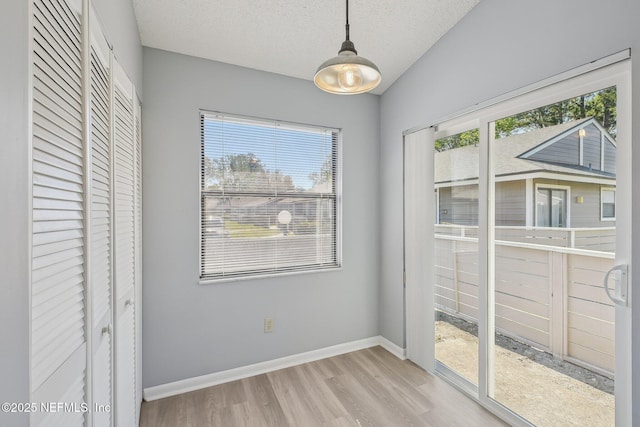 8314 Derbyshire Pl, Jacksonville, FL 32244 - unfurnished dining area featuring baseboards, lofted ceiling, a textured ceiling, and wood finished floors