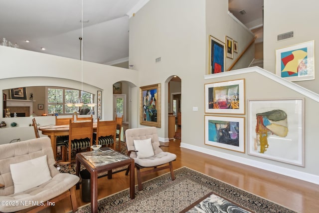 95062 Mackinas Cir, Fernandina Beach, FL 32034 - living area featuring visible vents, wood finished floors, high vaulted ceiling, and arched walkways