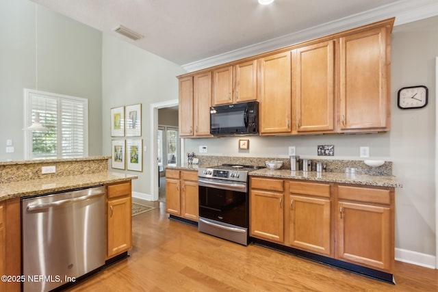 95062 Mackinas Cir, Fernandina Beach, FL 32034 - kitchen featuring visible vents, light stone counters, light wood-style floors, and appliances with stainless steel finishes