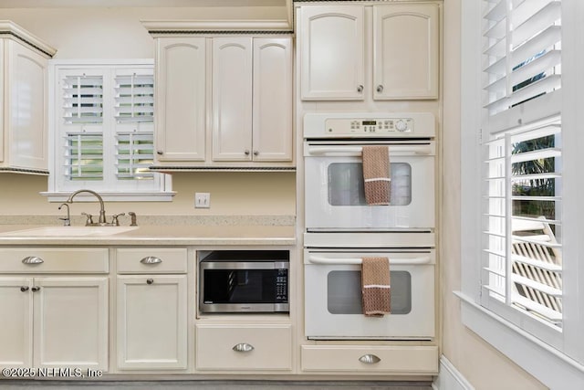 29 Grant St, Saint Augustine, FL 32084 - kitchen with double oven, a sink, stainless steel microwave, and light countertops
