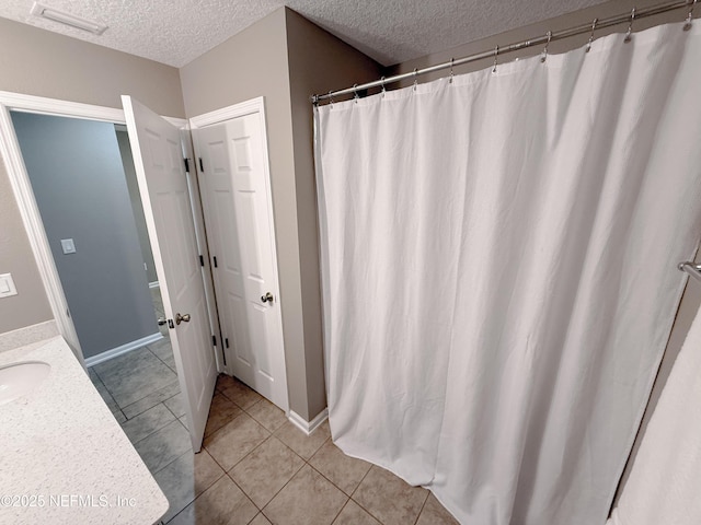 3118 Steeple Pine Ct, Middleburg, FL 32068 - bathroom with a textured ceiling, tile patterned floors, vanity, baseboards, and curtained shower