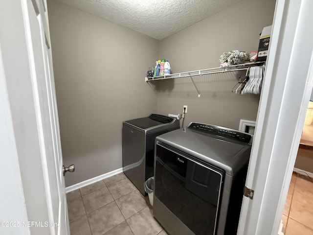 3118 Steeple Pine Ct, Middleburg, FL 32068 - laundry room with washer and clothes dryer, light tile patterned floors, baseboards, and a textured ceiling