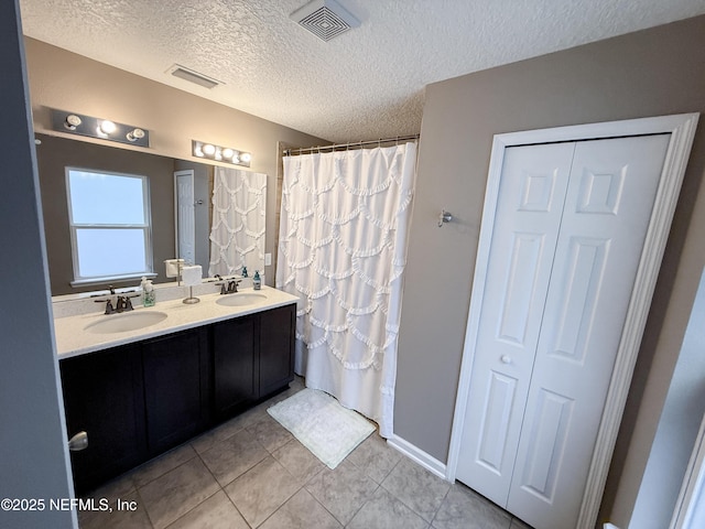 3118 Steeple Pine Ct, Middleburg, FL 32068 - bathroom with tile patterned floors, a closet, a textured ceiling, double vanity, and curtained shower