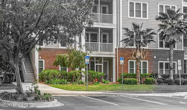 view of property featuring stairs and uncovered parking