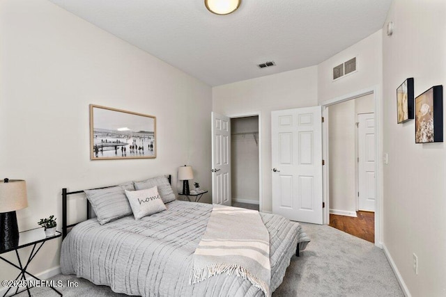 bedroom featuring baseboards, visible vents, a closet, and carpet