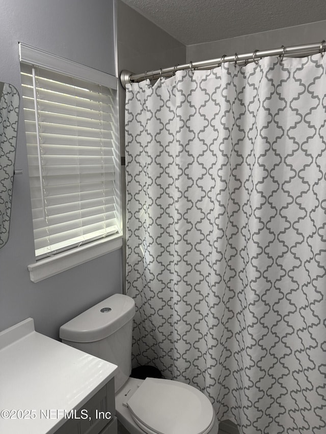 13248 Grant Logan Ln, Jacksonville, FL 32225 - full bathroom featuring toilet, vanity, curtained shower, and a textured ceiling