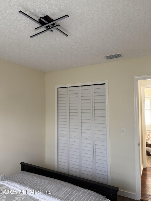 13248 Grant Logan Ln, Jacksonville, FL 32225 - unfurnished bedroom with dark wood-type flooring, a textured ceiling, visible vents, a ceiling fan, and a closet