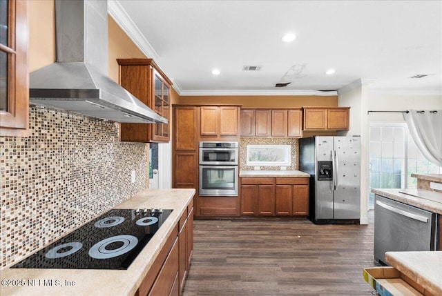 94245 Palm Cir W, Fernandina Beach, FL 32034 - kitchen featuring stainless steel appliances, decorative backsplash, visible vents, wall chimney range hood, and brown cabinets