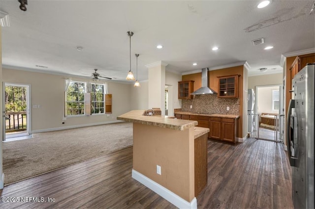 94245 Palm Cir W, Fernandina Beach, FL 32034 - kitchen featuring freestanding refrigerator, wall chimney exhaust hood, black electric cooktop, brown cabinetry, and visible vents