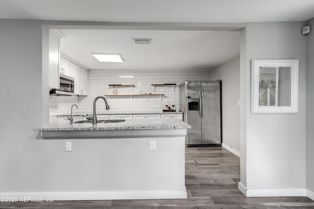 6013 Edgefield Dr, Jacksonville, FL 32205 - kitchen featuring white cabinetry, a peninsula, stainless steel appliances, visible vents, and decorative backsplash