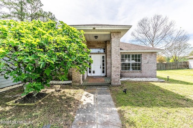 9587 Ford Rd, Bryceville, FL 32009 - property entrance with brick siding, fence, covered porch, and a yard