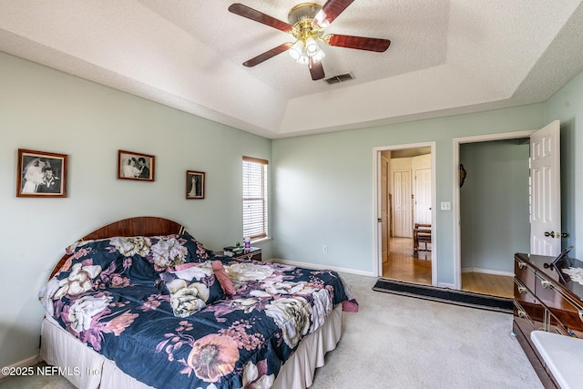 9587 Ford Rd, Bryceville, FL 32009 - carpeted bedroom featuring a tray ceiling, a ceiling fan, a textured ceiling, baseboards, and visible vents