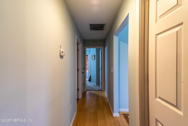 9587 Ford Rd, Bryceville, FL 32009 - hallway with baseboards, a textured ceiling, visible vents, and light wood-style floors
