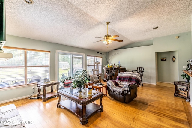 9587 Ford Rd, Bryceville, FL 32009 - living room with lofted ceiling, baseboards, light wood finished floors, visible vents, and ceiling fan