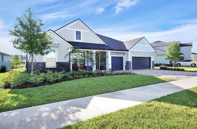 1021 Oakland Hills Ave, Middleburg, FL 32068 - view of front facade with stone siding, board and batten siding, a garage, and a front lawn