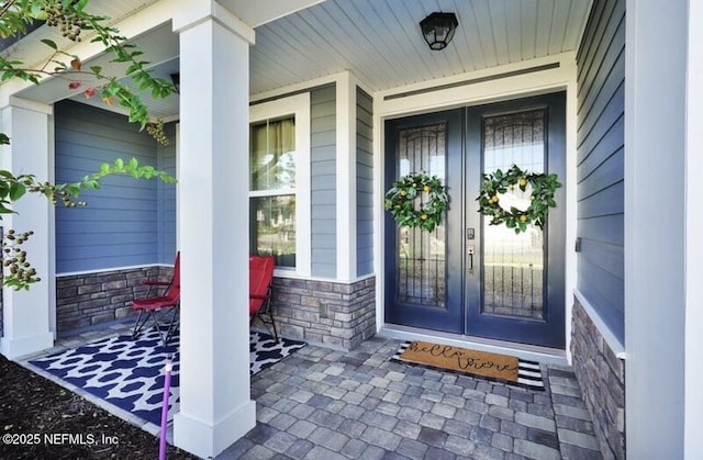 1021 Oakland Hills Ave, Middleburg, FL 32068 - doorway to property with stone siding, covered porch, and french doors