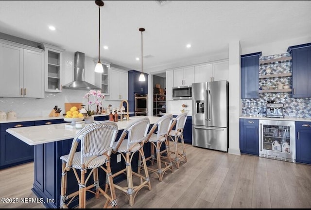 1021 Oakland Hills Ave, Middleburg, FL 32068 - kitchen featuring blue cabinets, appliances with stainless steel finishes, wine cooler, and wall chimney exhaust hood