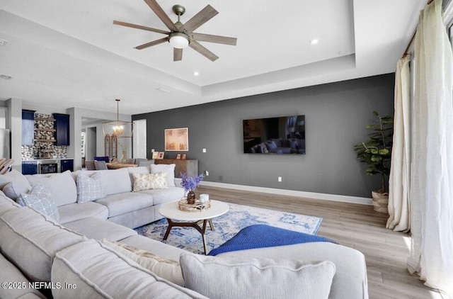 1021 Oakland Hills Ave, Middleburg, FL 32068 - living room featuring baseboards, a tray ceiling, light wood-style flooring, and ceiling fan