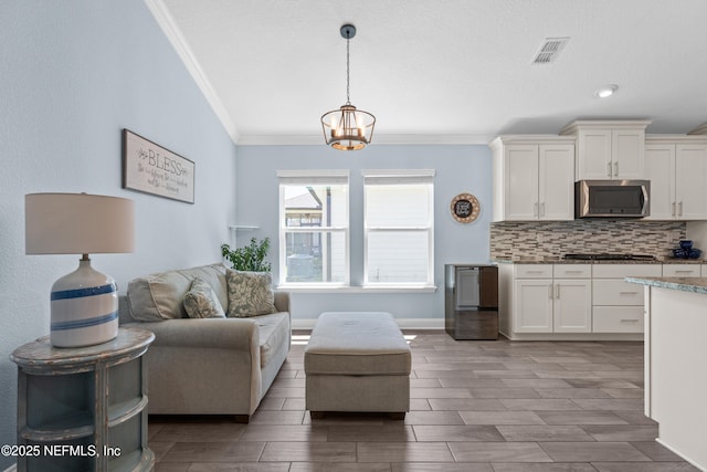 116 Providence Dr, Saint Augustine, FL 32092 - living area with ornamental molding, visible vents, a chandelier, and wood finish floors
