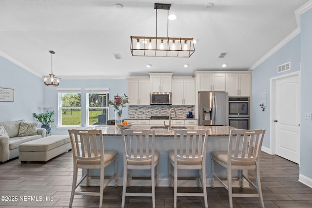 116 Providence Dr, Saint Augustine, FL 32092 - kitchen featuring visible vents, crown molding, appliances with stainless steel finishes, a sink, and backsplash