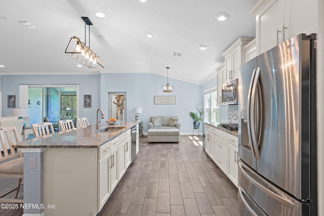 116 Providence Dr, Saint Augustine, FL 32092 - kitchen featuring visible vents, vaulted ceiling, a sink, and stainless steel appliances