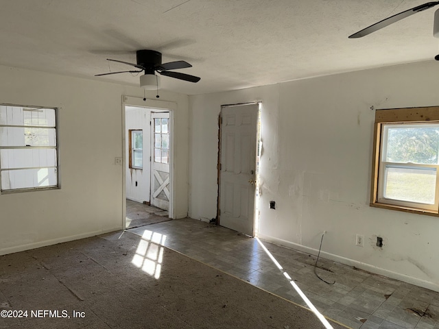 empty room featuring a ceiling fan, baseboards, and a textured ceiling