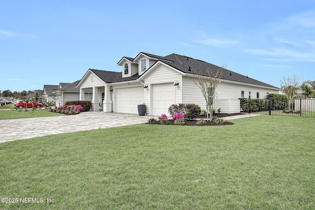 view of side of property with fence, decorative driveway, an attached garage, roof with shingles, and a yard