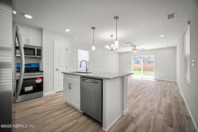 8910 Free Ave, Jacksonville, FL 32211 - kitchen featuring visible vents, a sink, light wood-style floors, a textured ceiling, and stainless steel appliances