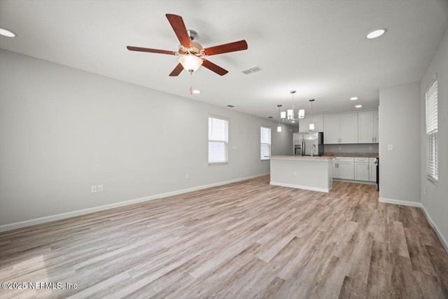 8910 Free Ave, Jacksonville, FL 32211 - unfurnished living room featuring light wood finished floors, baseboards, a ceiling fan, and visible vents