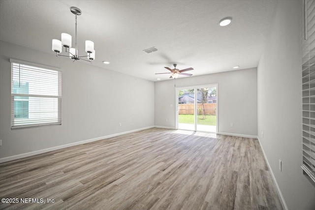 8910 Free Ave, Jacksonville, FL 32211 - spare room with baseboards, a textured ceiling, light wood-style floors, and ceiling fan with notable chandelier